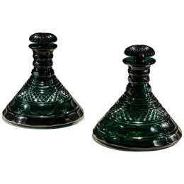 A RARE PAIR OF HEAVILY CUT EMERALD GREEN DECANTERS