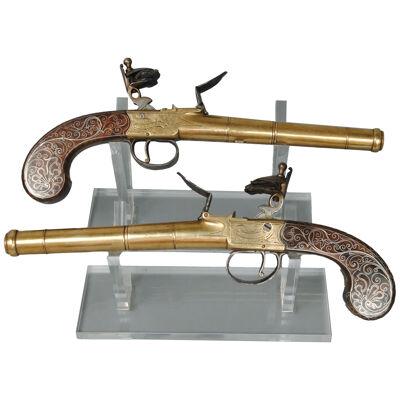 A FINE PAIR OF SILVER INLAID BRASS BARRELLED PISTOLS BY BUNNEY LONDON