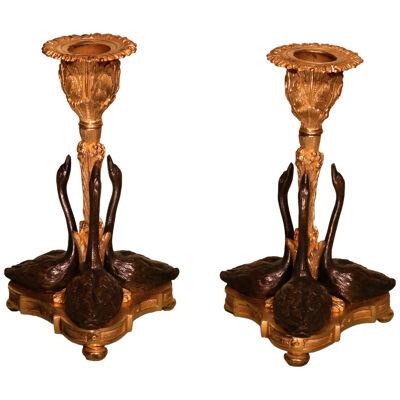 A pair of mid 19th century bronze and ormolu swan candlesticks